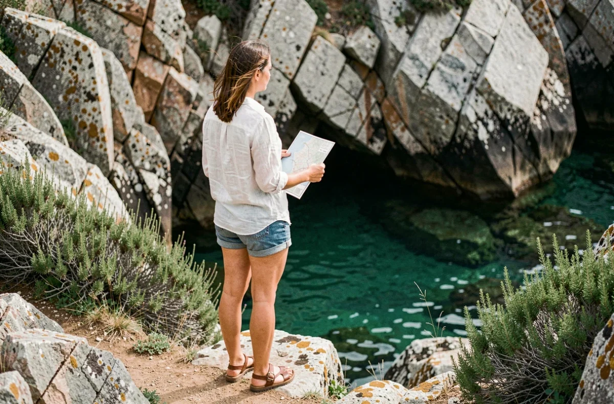 Femme voyageuse contemplant une crique secrète lors d'un road trip sur la côte espagnole